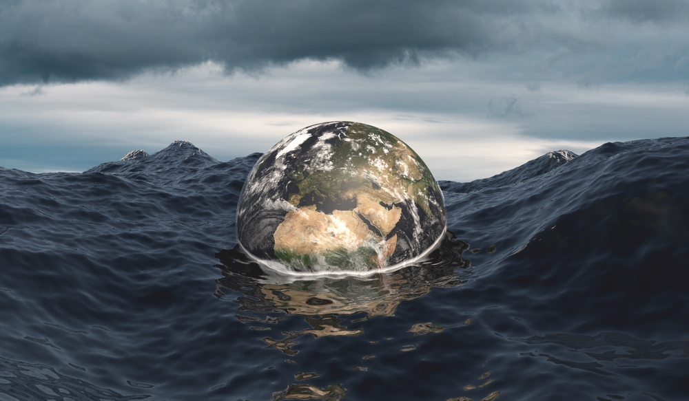 The globe sinks into the ocean. Rising sea level. Stormy ocean and dramatic sky. Global warming, climate change concept. Earth map from NASA gov. 3D illustration.
