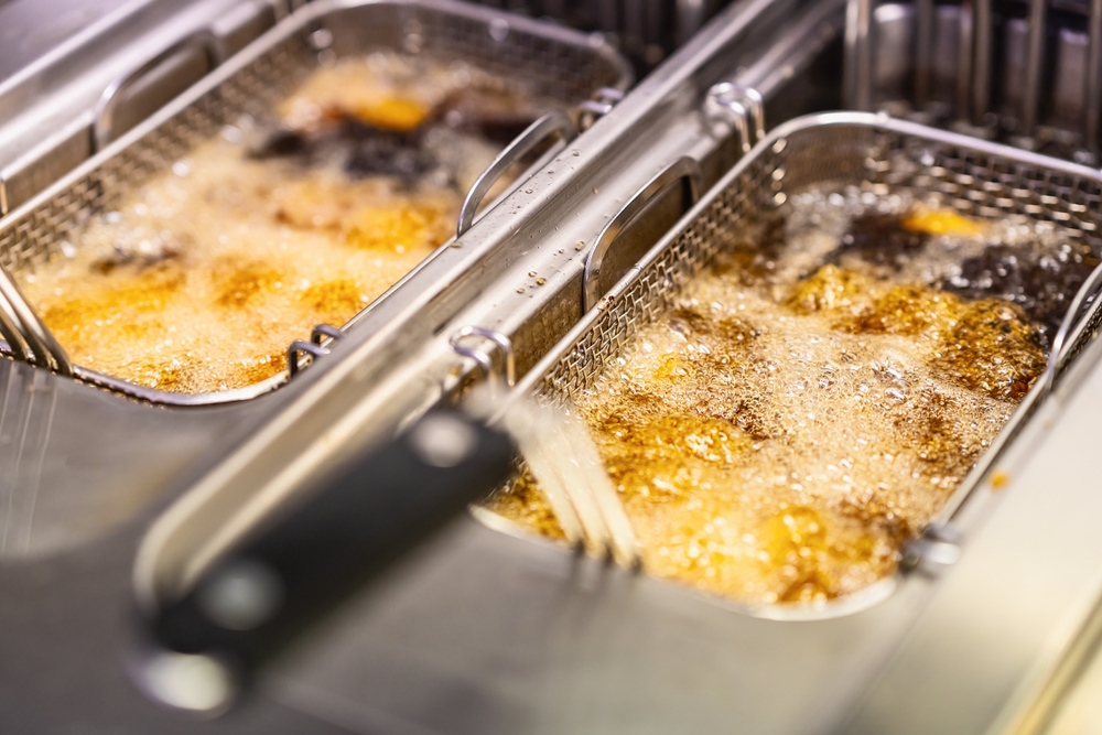 Cooking french fries. Close up of Frying french fries in the fryer in hot oil