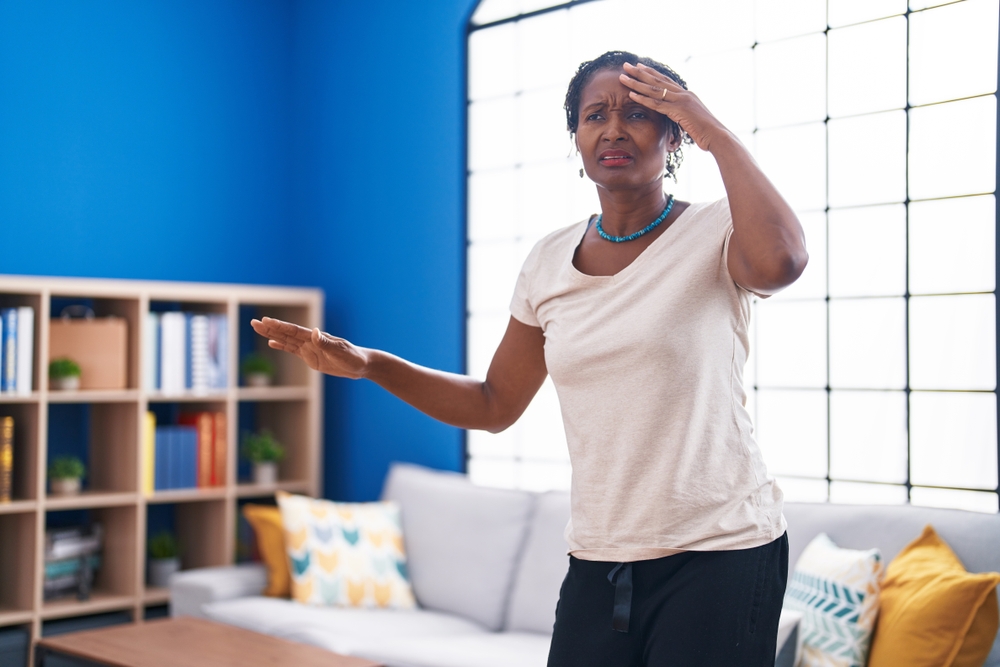 Middle age african american woman suffering dizzy standing at home