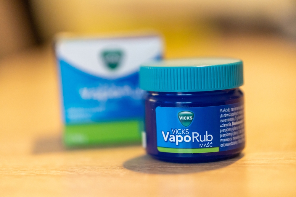 POZNAN, POLAND - Jun 09, 2022: A Vicks VapoRub skin cream in a box and jar on a table
