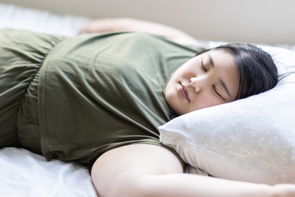 woman lying on her back in bed