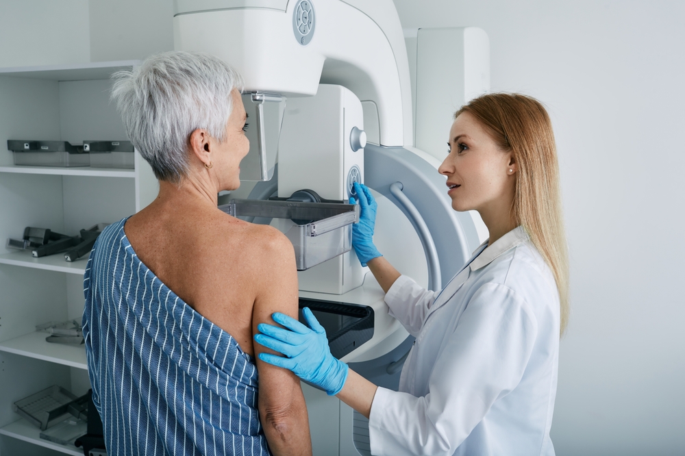 Senior woman having mammography scan at hospital with medical technician. Mammography procedure, breast cancer prevention
