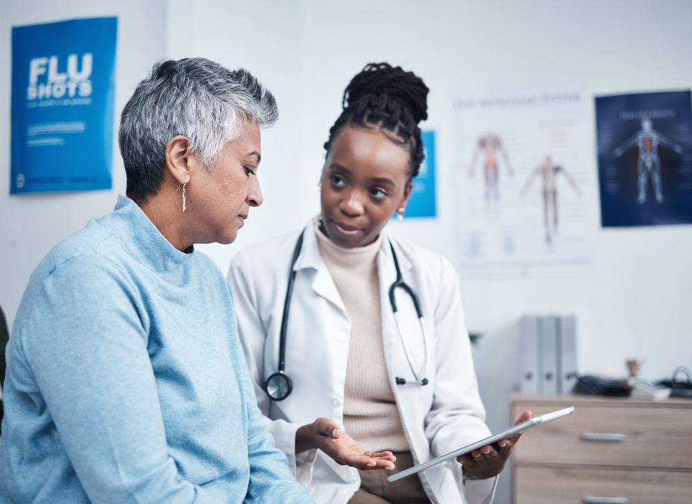 Black woman, doctor and senior patient with tablet, results and listen for health planning, advice or cancer. African medic, mobile touchscreen and healthcare with trust, tech and support in hospital
