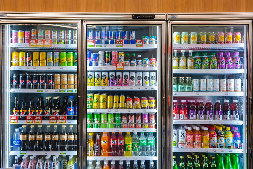 KUALA LUMPUR, MALAYSIA - MAY 22, 2023: Variety of energy drinks, soda, soft drinks, fruit juice, non-carbonated, in bottles and cans on the shelves in a 7 Eleven convenience store. Beverages industry.