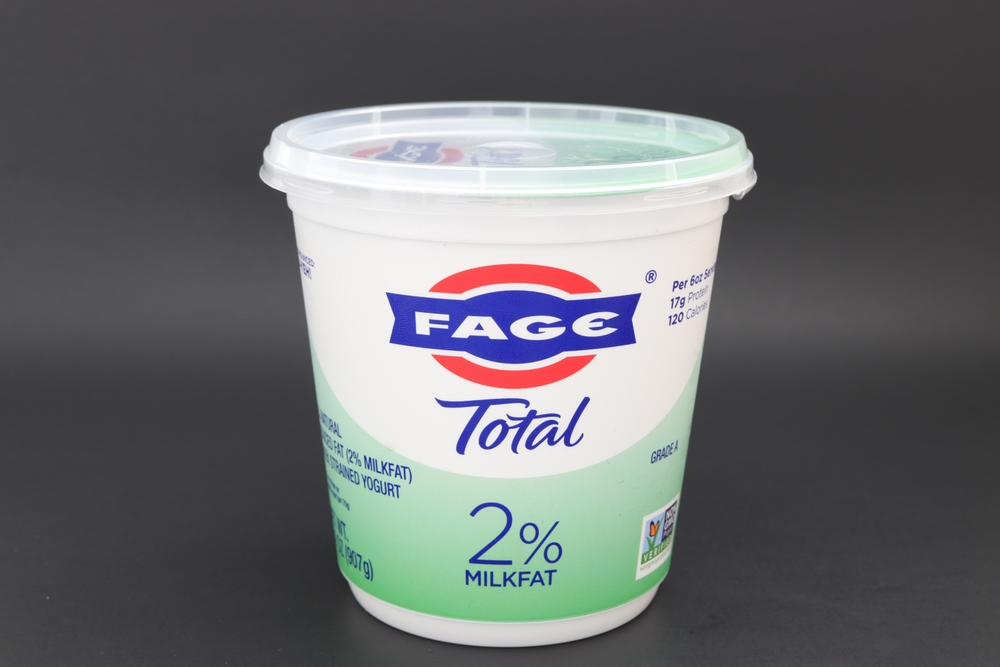 MIAMI, FLORIDA USA - 06-08-2023 Single container of low fat FAGE Greek Yogurt isolated against dark background.