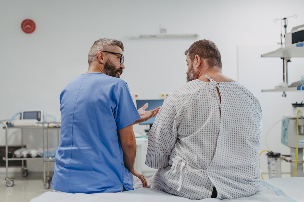 Supportive doctor soothing a worried overweight patient, discussing test result in emergency room. Illnesses and diseases in middle-aged men's health. Compassionate physician supporting stressed
