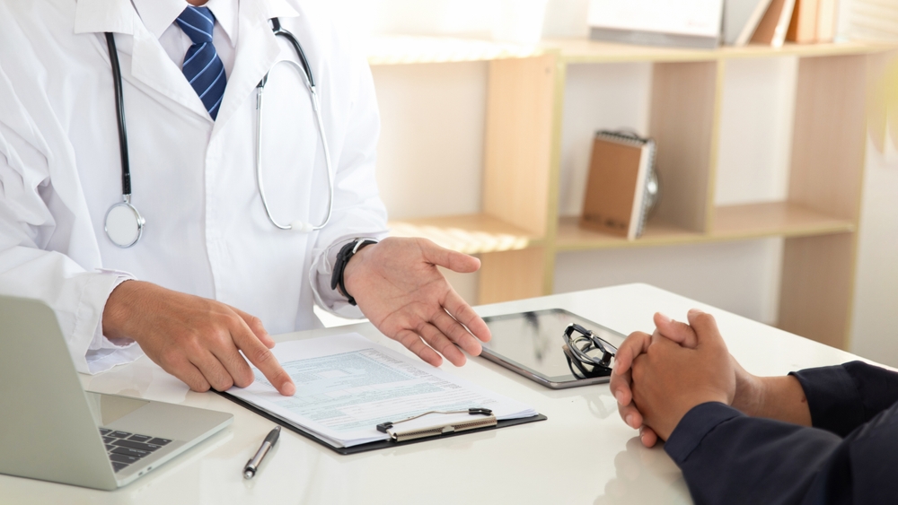 Medicine and healthcare concept. doctor and patient discussing current health examination while sitting in clinic. Medical care, insurance, prescription, paper work. annual physical examination.