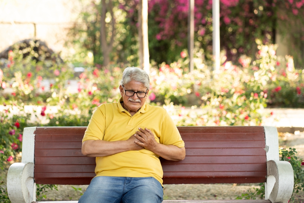 Heart attack concept.. Indian Senior man suffering from chest pain outdoor in park,

