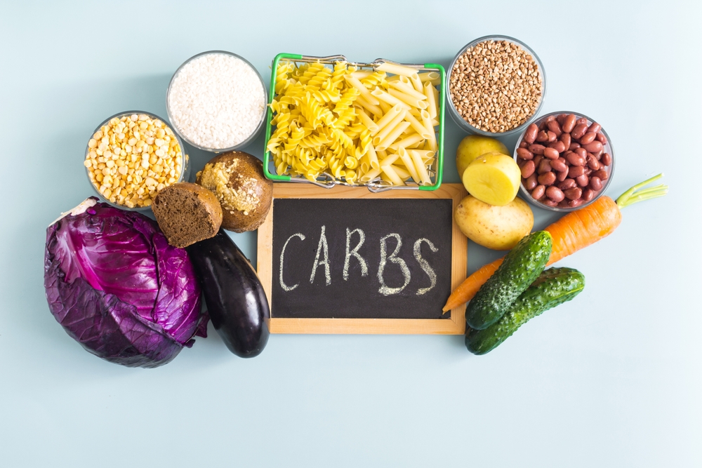 A set of foods containing complex carbohydrates, and the inscription on the "carbohydrates" sign in close-up.