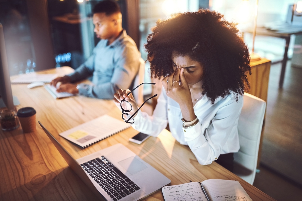 Business, woman and headache from eye strain at desk with stress, overworked and work deadline at night. Professional, employees and fatigue in coworking office with burnout, internet glitch and pain
