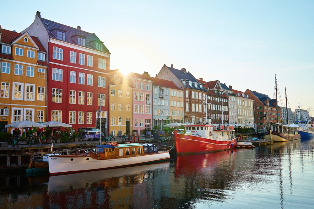 Nyhavn Harbor in Copenhagen. Famous tourist spot in Denmark with colorful historical buildings and boats on Nyhavn waterfront. Traveling in Scandinavian country. Copenhagen, Denmark - June 26, 2024
