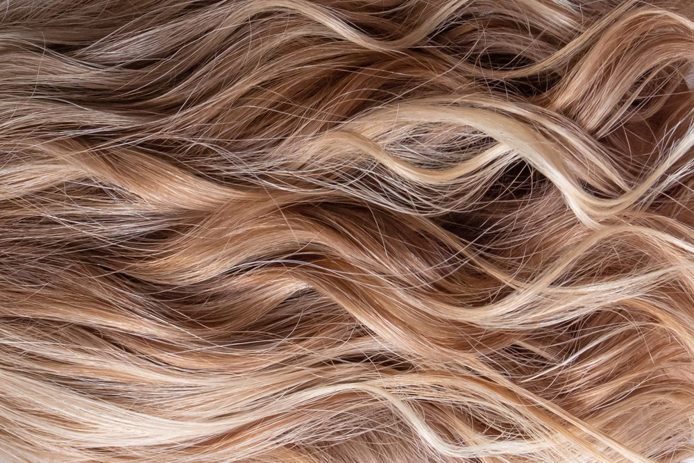 Blonde hair texture swatch. Wavy styling. Bright highlights. Hair color.