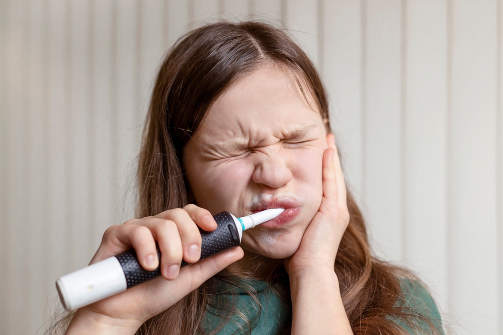 Teeth Hurt when Brushing Teeth using Electric Toothbrush. Toothpaste and Toothbrash for Sensitive Teeth. Pain and Discomfort during Brushing Teeth.