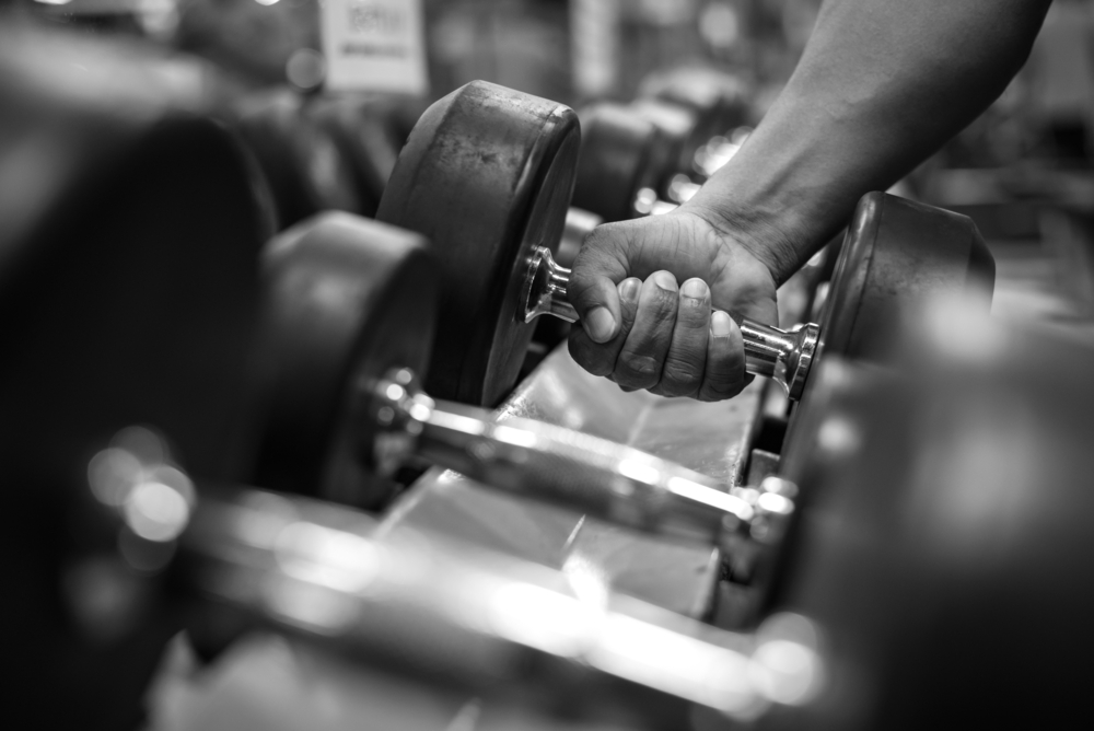 Black and white images Hand holding dumbbell in the gym bodybuilding.
