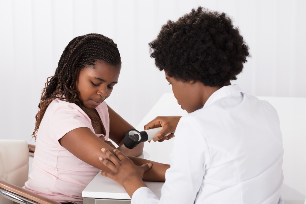 Female Doctor Examining Skin Of Girl With Dermatoscope In A Clinic
