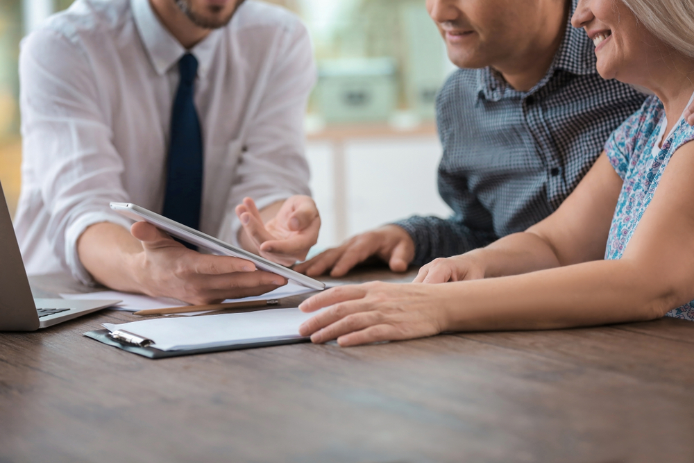 Male insurance agent consulting clients in office
