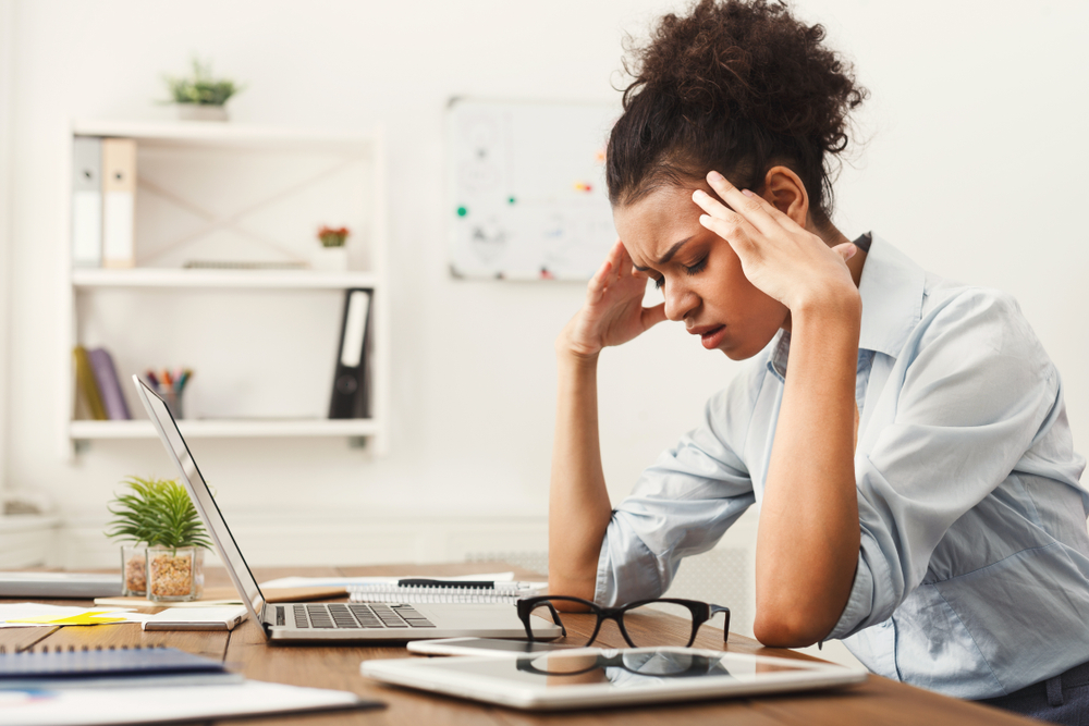 Tired african-american business woman with headache at office, feeling sick at work, copy space
