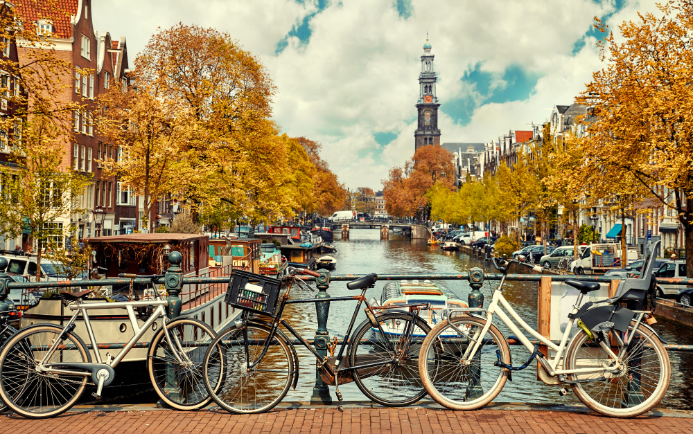 Bike over canal Amsterdam city. Picturesque town landscape in Netherlands with view on river Amstel.
