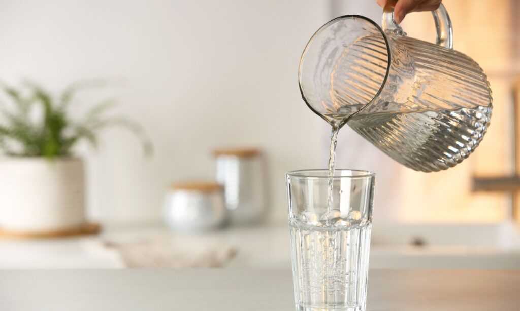 water being poured into a glass from a jug