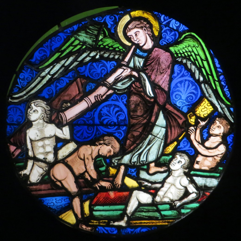 A medieval stained glass window depicting an angel with green wings and a golden halo. The angel is shown in traditional medieval style with several nude human figures below, possibly representing souls. The background is rich blue with decorative patterns.