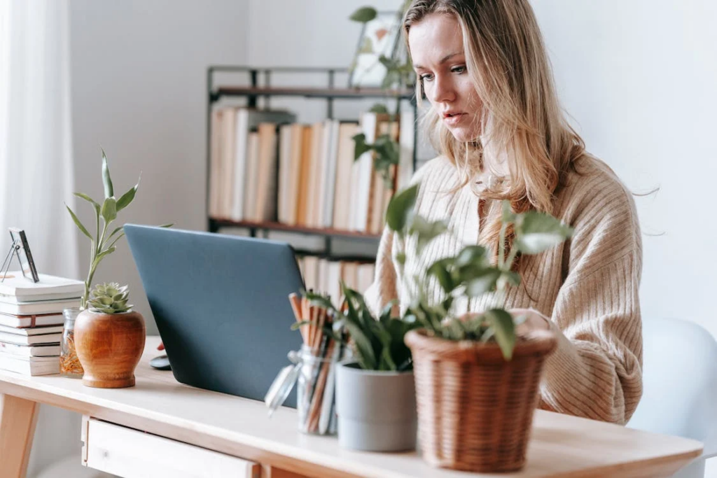 Crop serious freelancer working on laptop at home desk