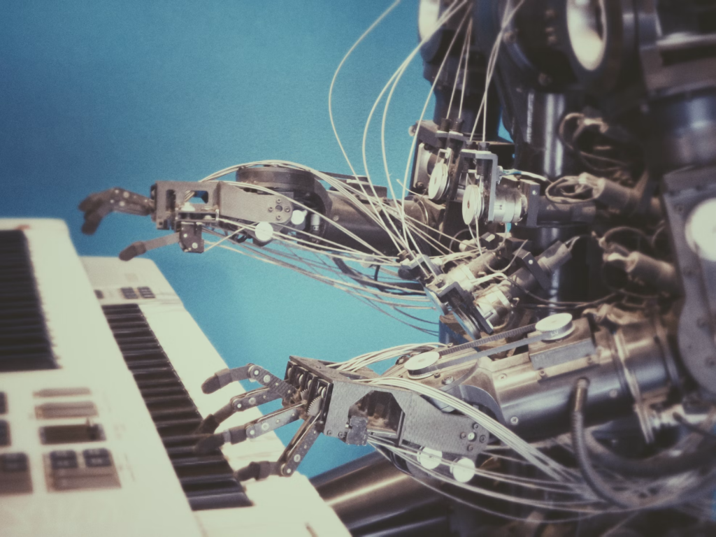 Robotic hands positioned over a keyboard, illustrating the advancing AI capabilities that Gates identifies as requiring careful control.