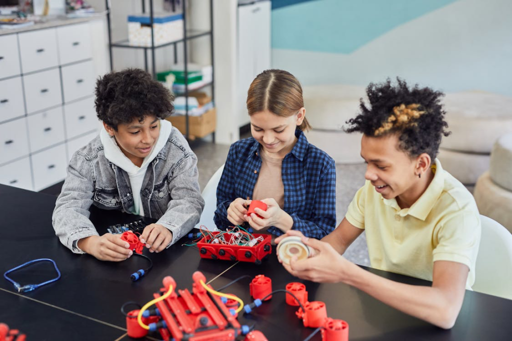 Young students collaborating on a robotics project, representing how education prepares future generations to overcome threats to younger generations through STEM skills and innovation.