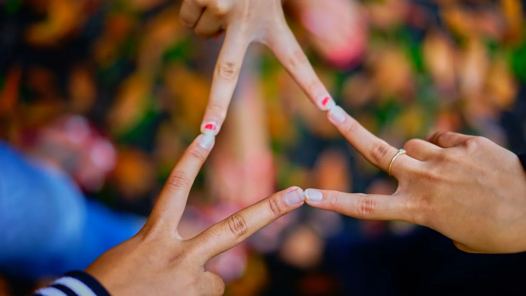 Human connection represented by hands forming a triangle, illustrating the relationships we reflect on when conscious after death.