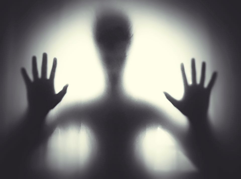 Silhouette of person against bright light symbolizing the transitional state of being conscious after death.