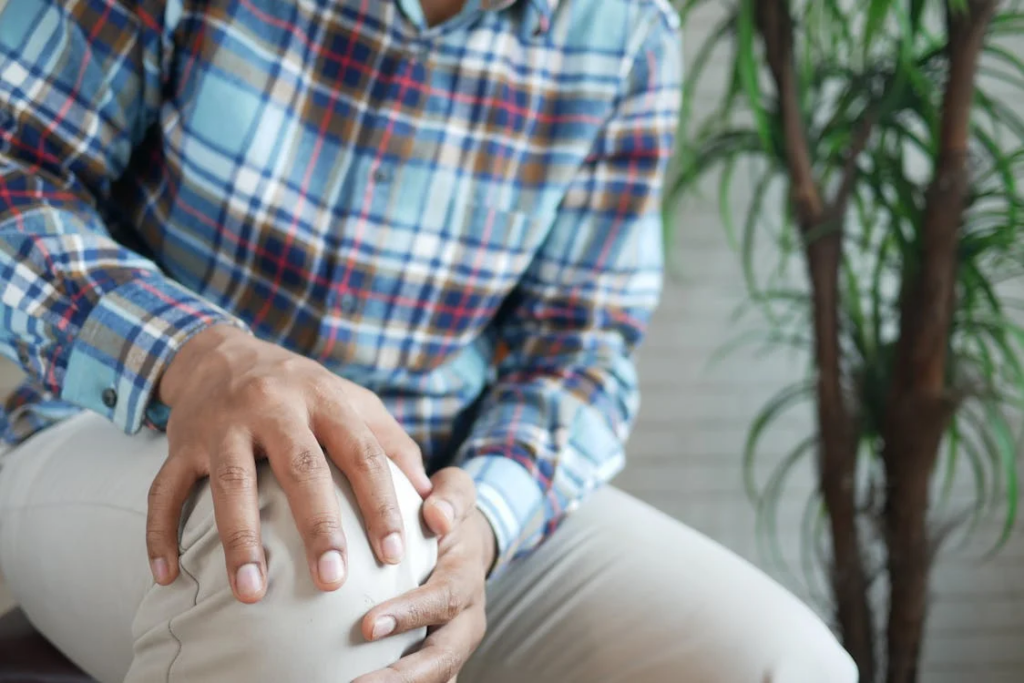  Person in Plaid Long Sleeves Holding His Knee