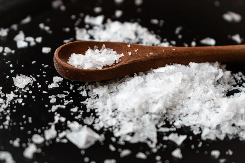 Wooden spoon with salt on table
