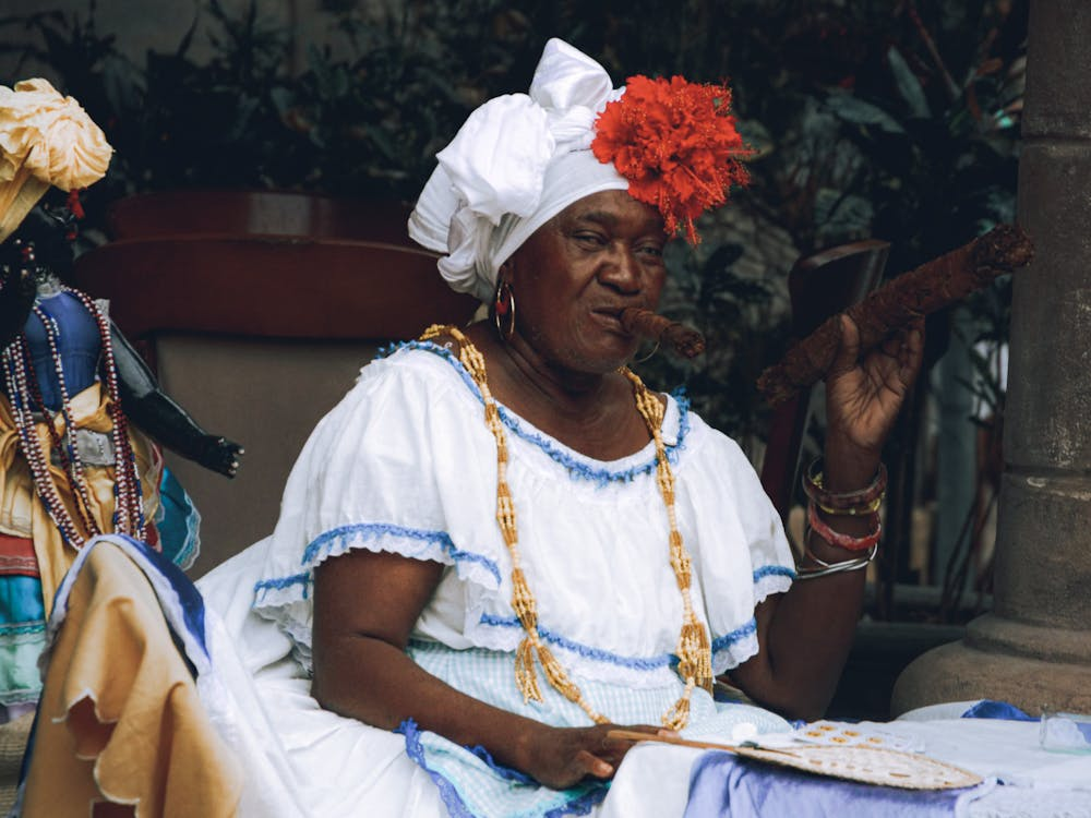 Photo of a Woman Wearing Vintage White Clothing, with Cigar in Her Mouth