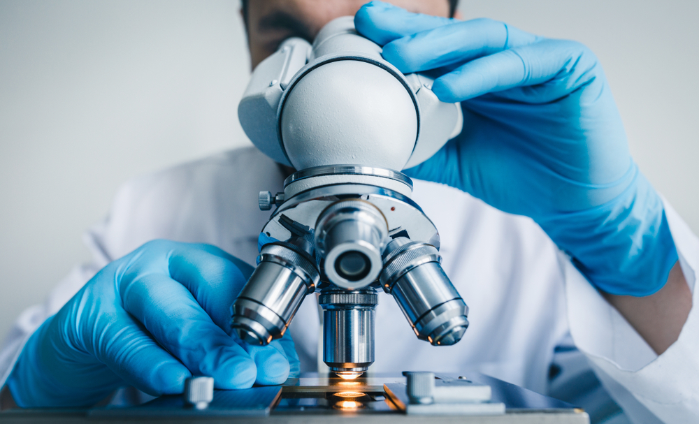 Close-up shot of microscope with metal lens at laboratory.
