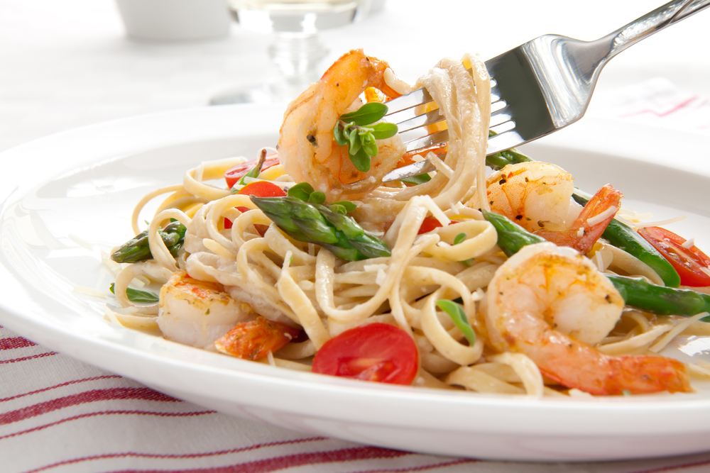 Healthy whole grain linguine with shrimps, asparagus, cherry tomatoes, fresh Parmesan cheese, and oregano.
