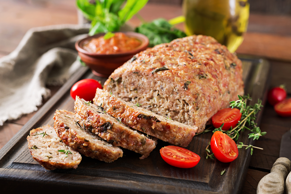 Tasty homemade ground baked turkey meatloaf on wooden table. Food american meat loaf.
