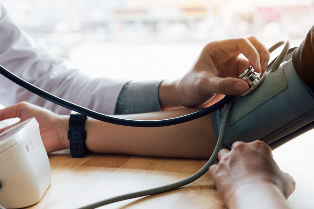 Doctor using stethoscope take a tap on the patient's arm in office room.
