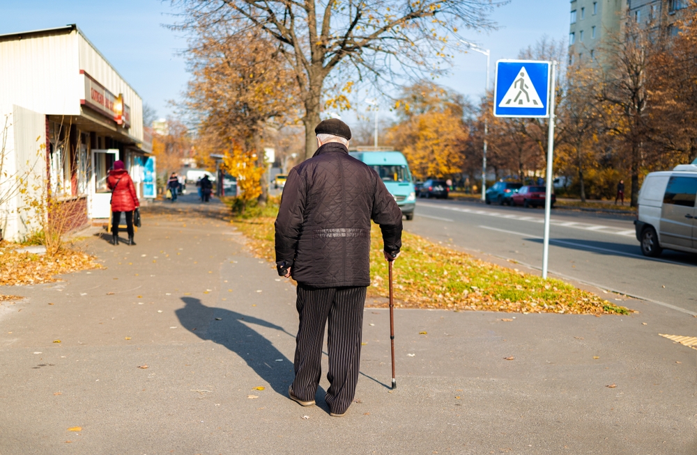 Unidentified old man with a cane walking in the city in Ukraine.
