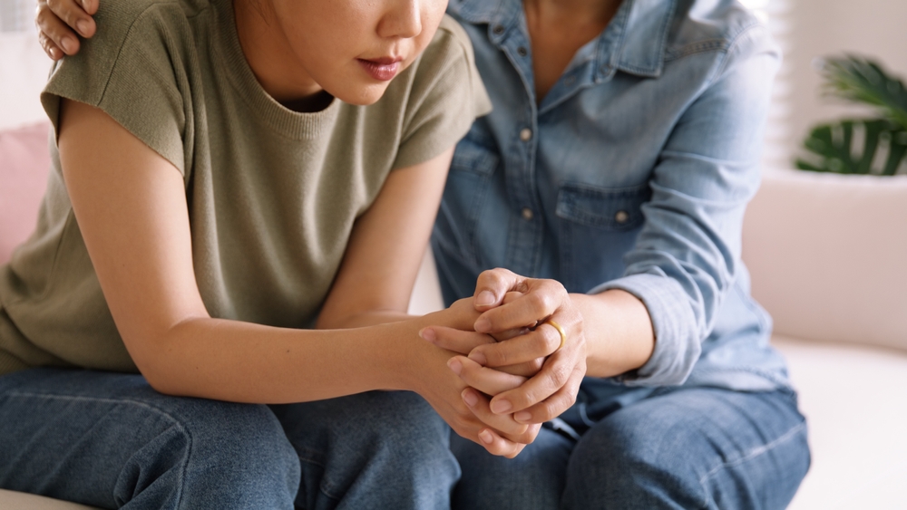 Middle aged asia people old mom holding hands trust comfort help young woman talk crying stress relief at home. Mum as friend love care hold hand adult child feel pain sad worry of life crisis issues.
