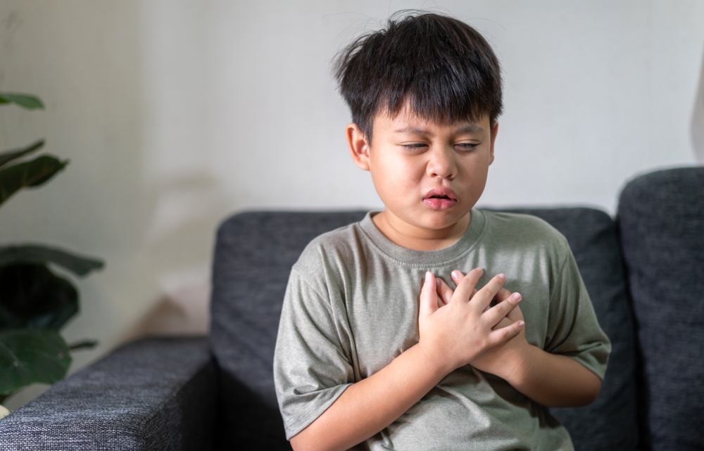 Asian boy with chest pain suffering from heart attack, health and medical, heart health, heart attack, world heart day, cardiovascular disease.insurance and hospital concept