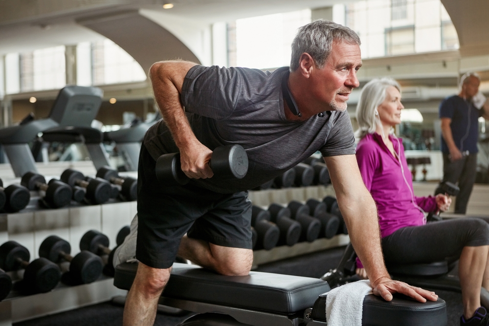 Fitness, weights and senior man in gym for workout, training and cardio exercise for healthy body. Retirement, sports and person with dumbbell equipment for wellness, muscle strength and mobility