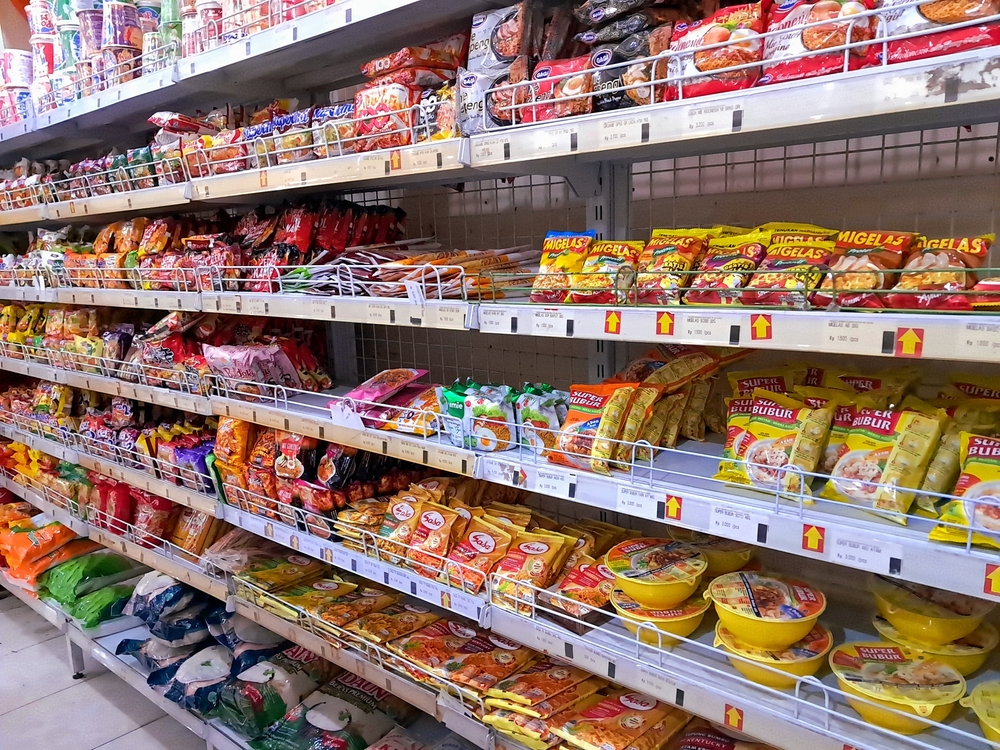 Various instant food from noodle, porridge, and seasonings aisle display at a local supermarket. Shop, dail consume. Assorted variety brands. Food industry business. Jogja, Indonesia - June 25, 2024
