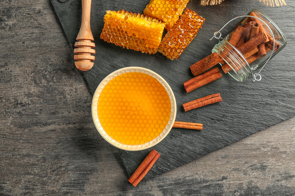 Composition with honey and cinnamon on wooden table
