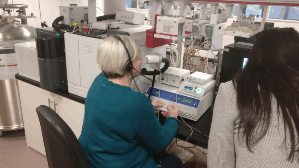 Joy trying the spectrometry tool in a lab setting. This shows how scientists figured out what the woman who smells illness was actually detecting.