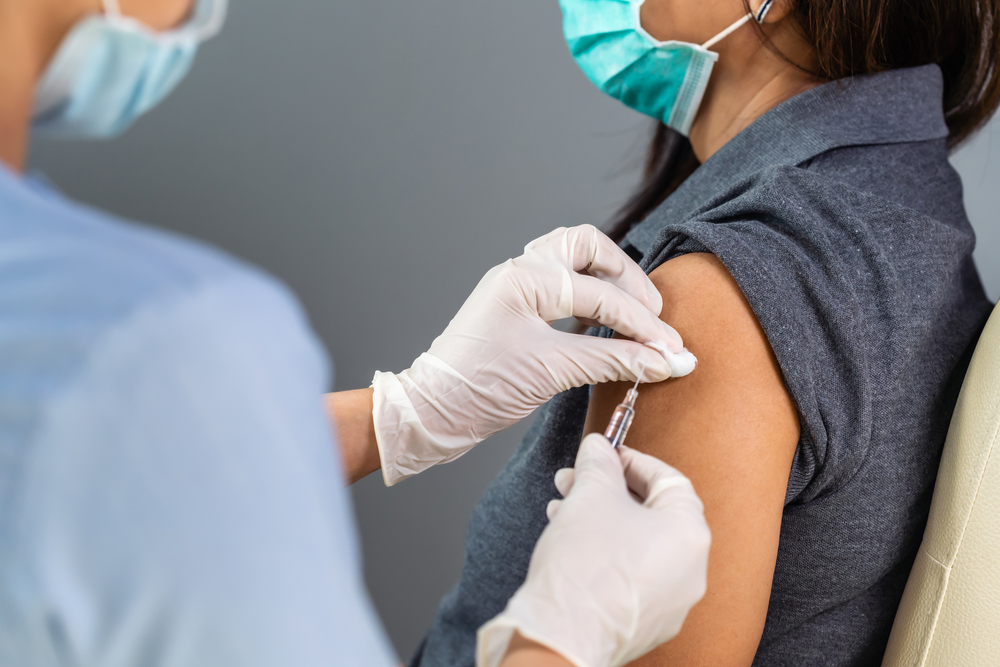 close up doctor holding syringe and using cotton before make injection to patient in medical mask. Covid-19 or coronavirus vaccine
