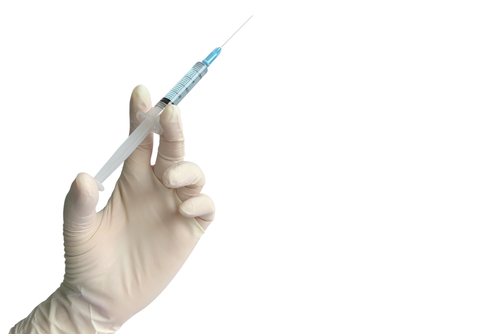 Close up doctor's hand in glove holding syringe with needle isolated on white background with copy space for medical treatment, vaccination, filler injection, cosmetic surgical, laboratory concept.