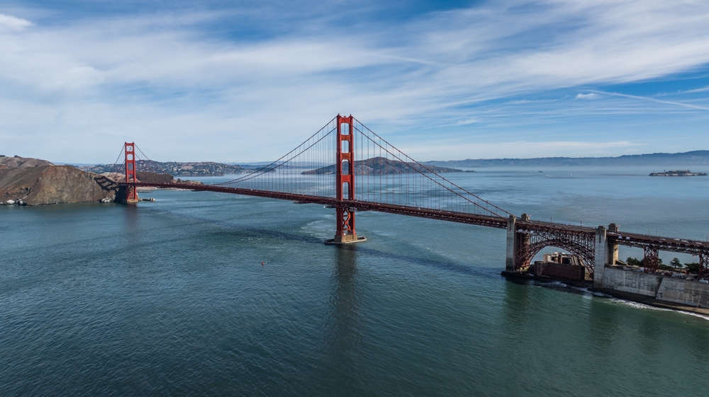 aerial landscape view of San Francisco Bay Area with Golden Gate Bridge in front and Alcatraz Island on right side 