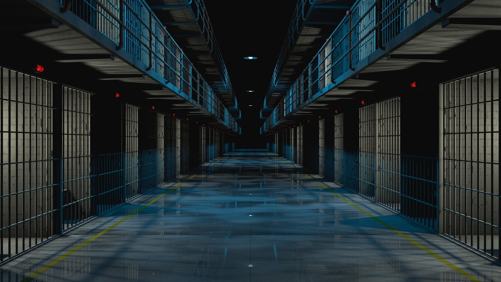Inside prison corridor at night. cells with lights on and wet floor. 3d rendering.