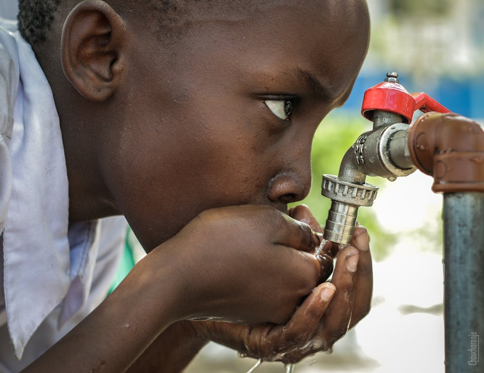 Boy Drinking Water on Faucet

