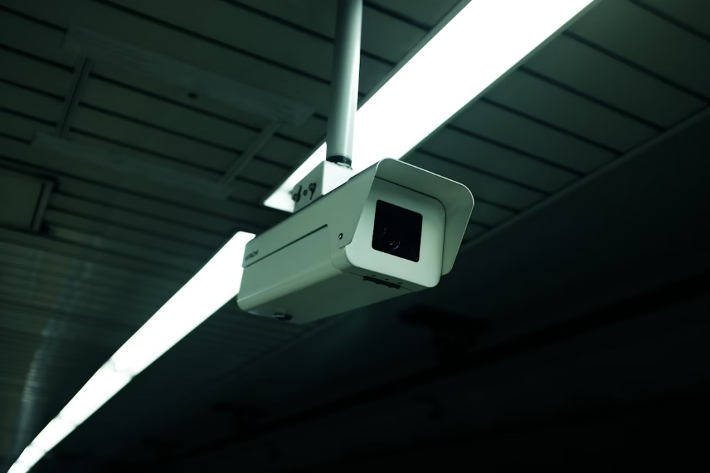 Security camera mounted on ceiling of airport terminal.