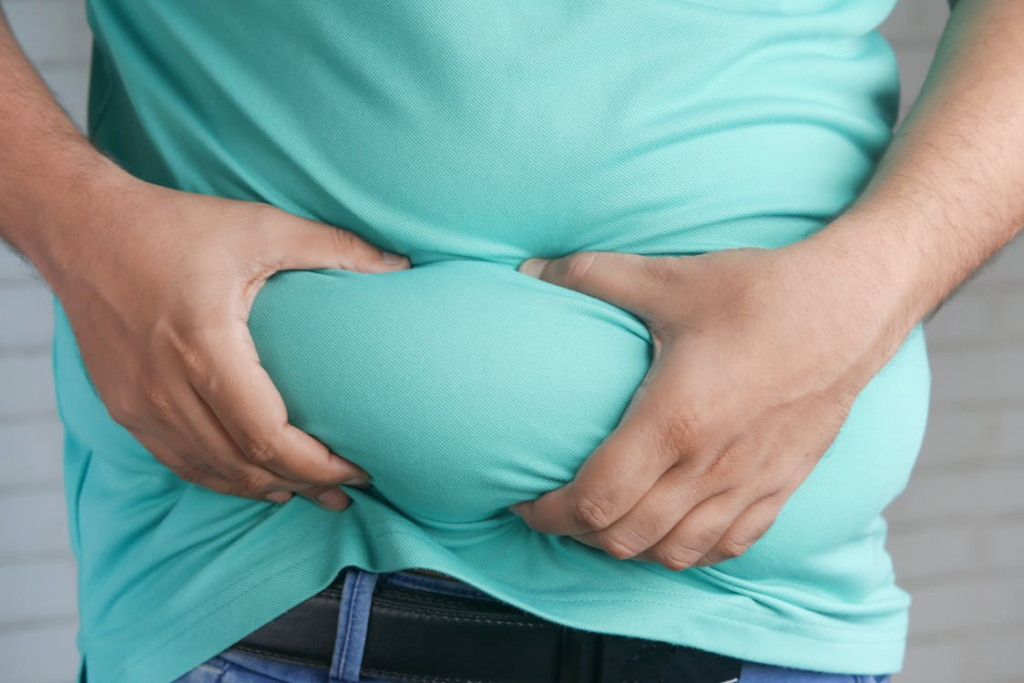 A Person Holding his Belly Fat
